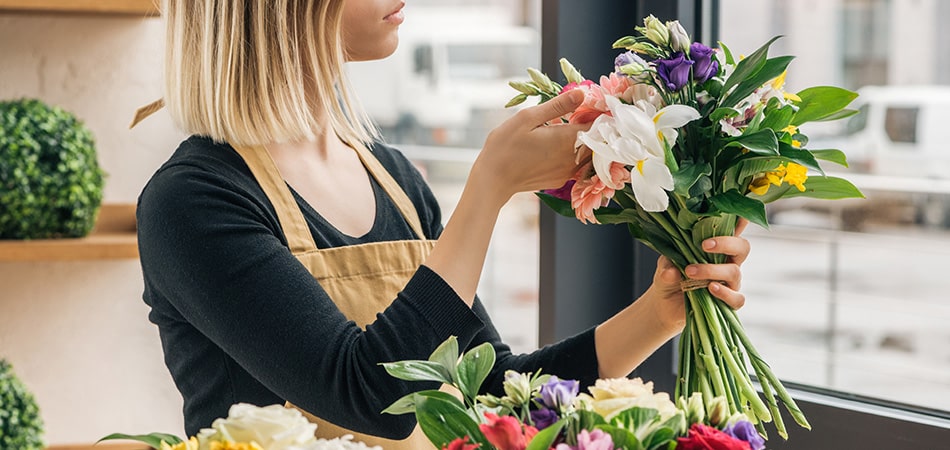 A woman holding a bouquet of flowers in her hand.